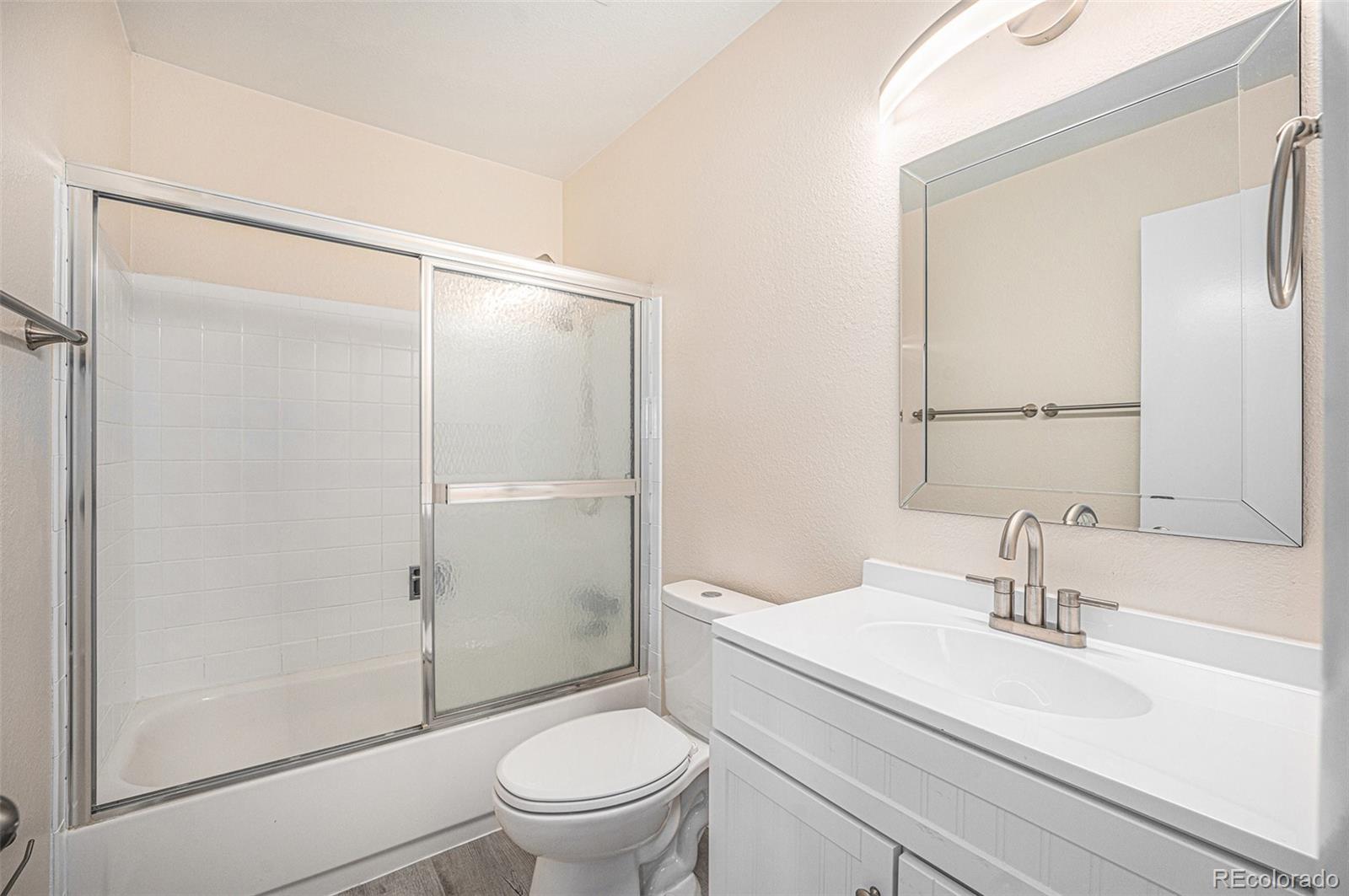 1830 Simms Street Lakewood, CO 80215 - Photo 18 of 31 a bathroom with a sink a mirror a toilet and shower
