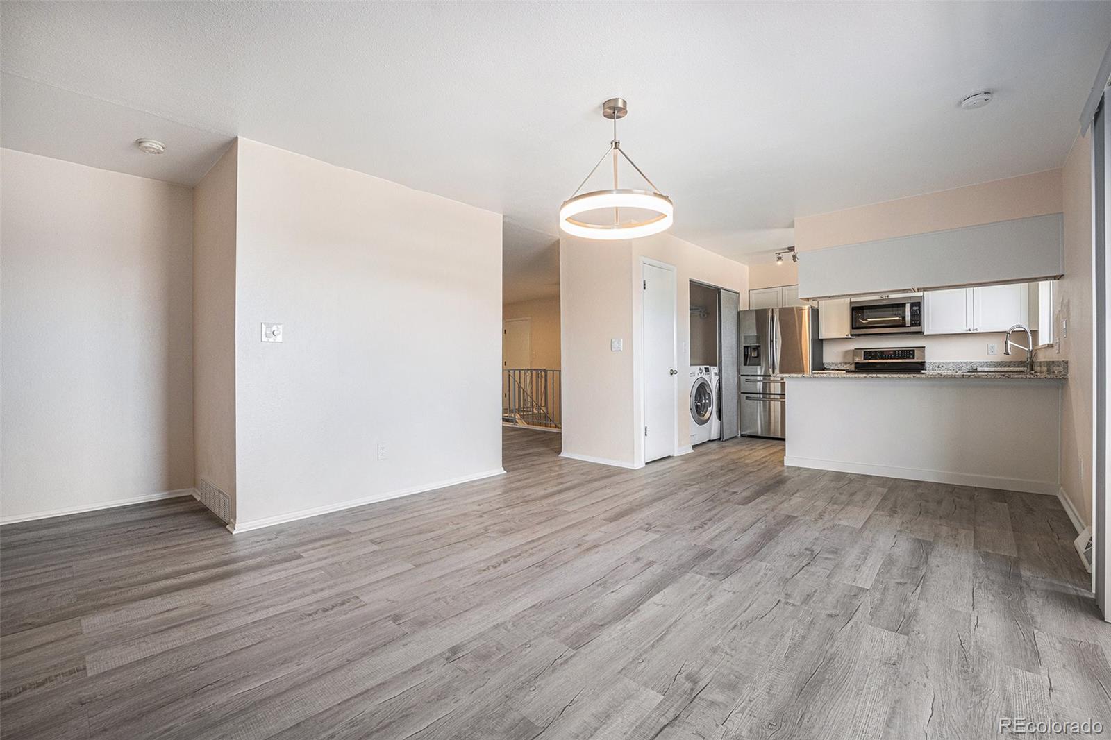 1830 Simms Street Lakewood, CO 80215 - Photo 9 of 31 a view of a kitchen with a microwave and wooden floor
