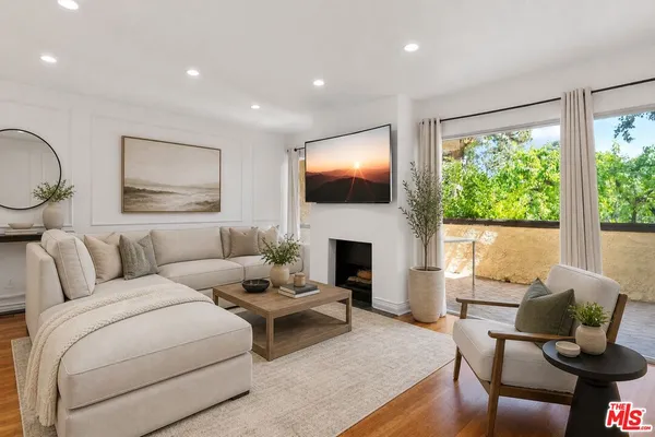 a living room with furniture a fireplace and a floor to ceiling window