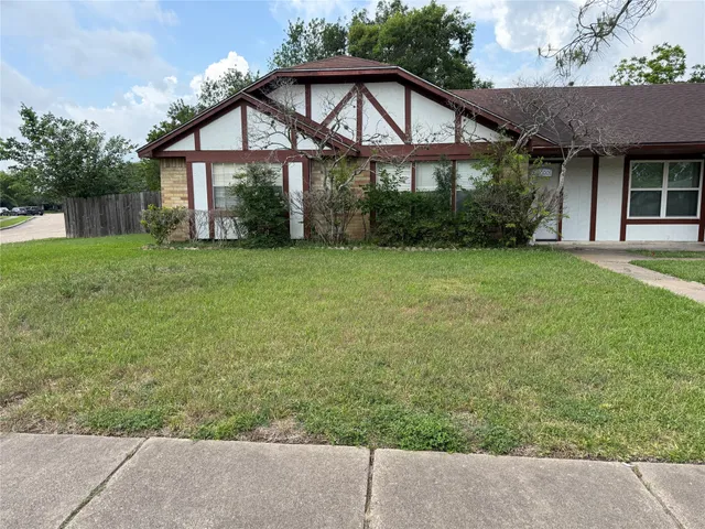 a front view of a house with a yard and potted plants