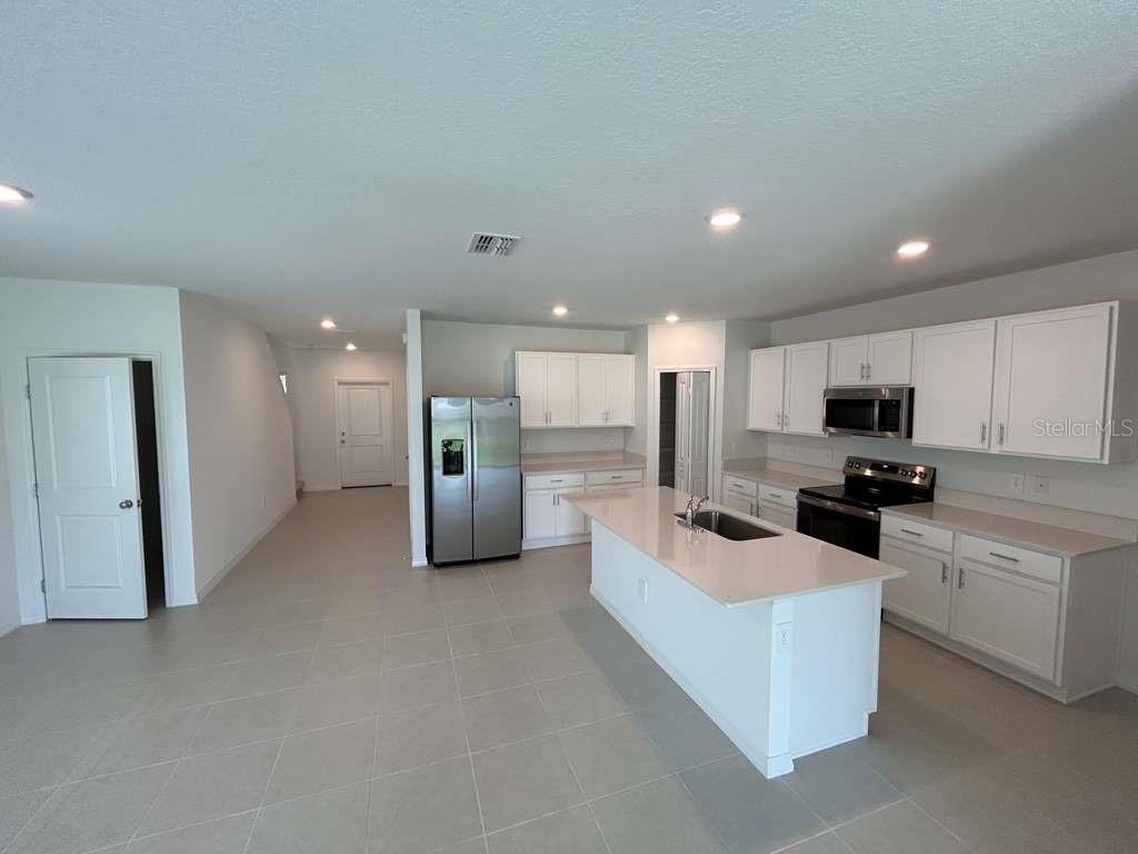 1140 Hour Glass Road Lakeland, FL 33801 - Photo 4 of 24 a living room with stainless steel appliances kitchen island furniture and a open kitchen view
