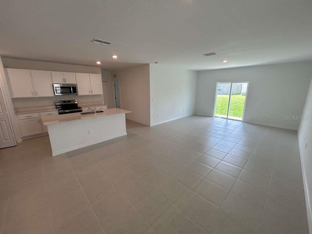 1140 Hour Glass Road Lakeland, FL 33801 - Photo 6 of 24 a living room with stainless steel appliances kitchen island granite countertop a refrigerator a stove top oven a sink and dishwasher