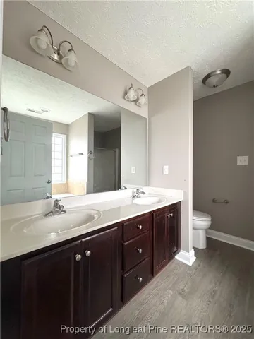 a spacious bathroom with a granite countertop sink mirror and toilet
