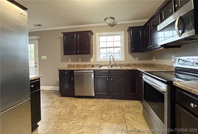 a kitchen with stainless steel appliances granite countertop a sink stove and microwave