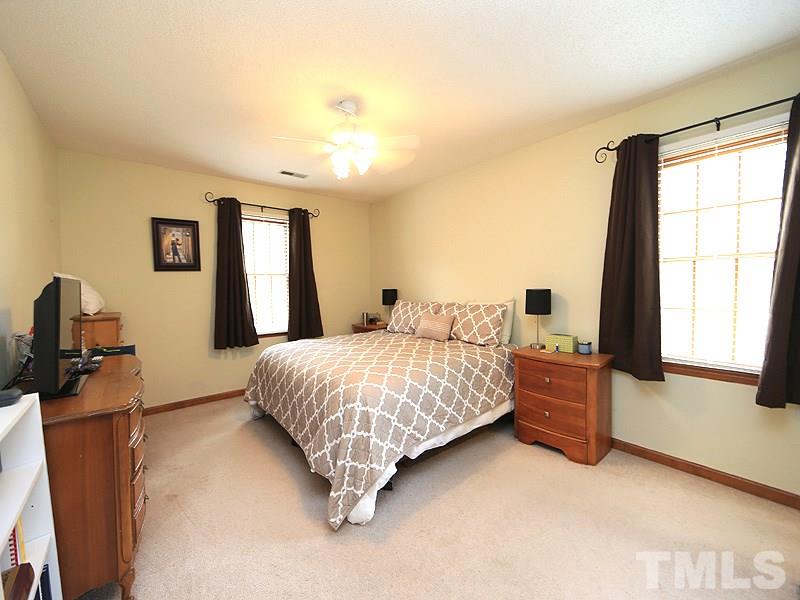 7301 Ewing Place Raleigh, NC 27616 - Photo 7 of 12 a bedroom with a bed and a flat tv screen on the dresser