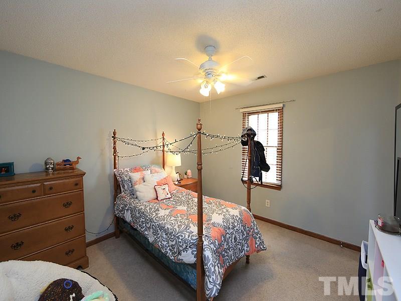 7301 Ewing Place Raleigh, NC 27616 - Photo 10 of 12 a bedroom with a bed and a chandelier