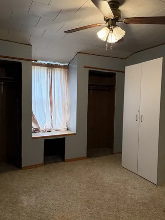 an empty room with windows and cabinet