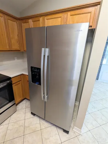 a kitchen with a refrigerator and a stove top oven