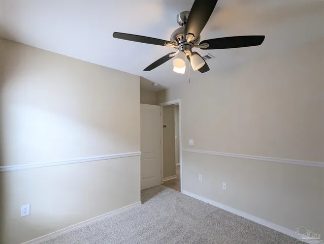 an empty room with closet and a chandelier fan