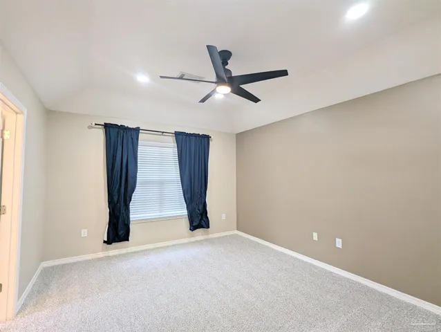 an empty room with closet and fan