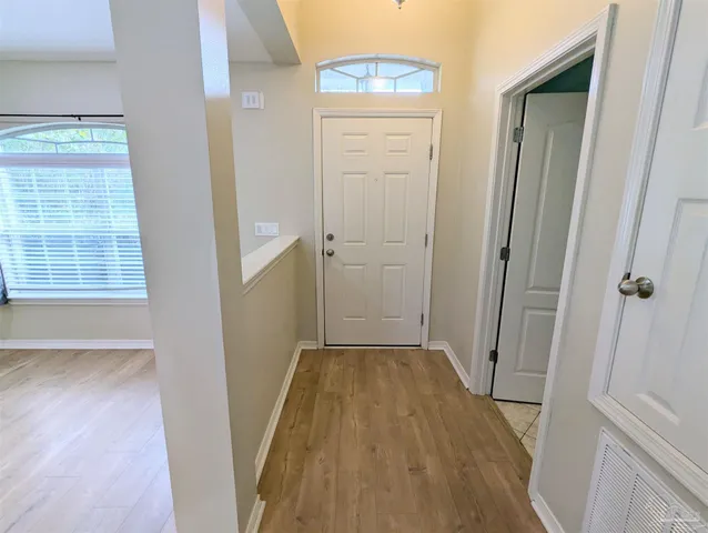 a view of a hallway with wooden floor and closet