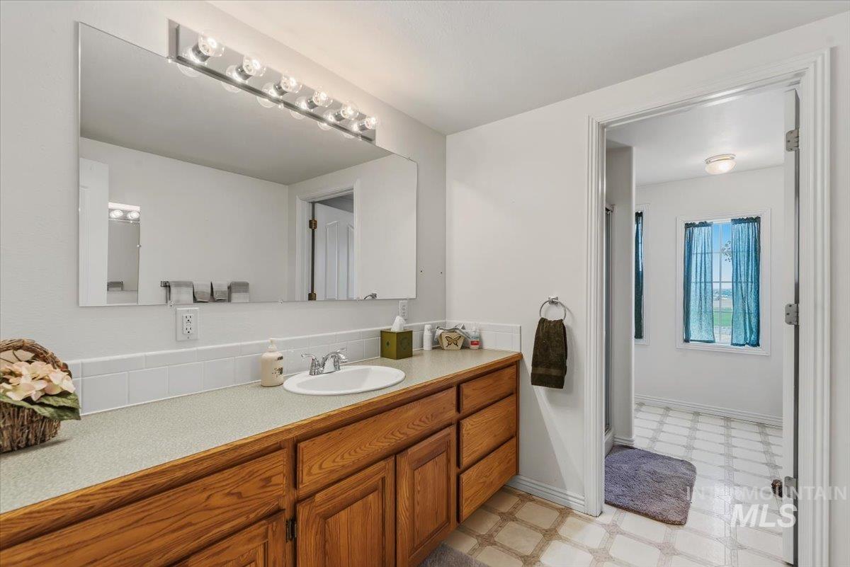 2331 Gulley Road Homedale, ID 83628 - Photo 22 of 46 Bathroom vanity featuring a large mirror, integrated lighting fixture, and a single sink with chrome faucet