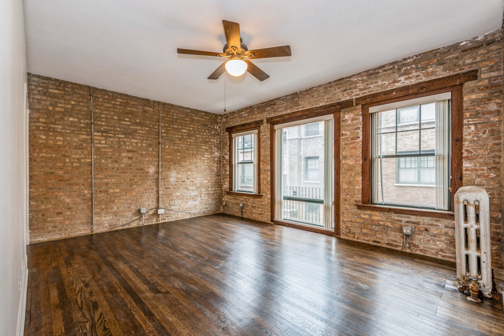 7023 North Sheridan Road, Unit 2E Chicago, IL 60626 - Photo 3 of 10 an empty room with wooden floor fan and windows