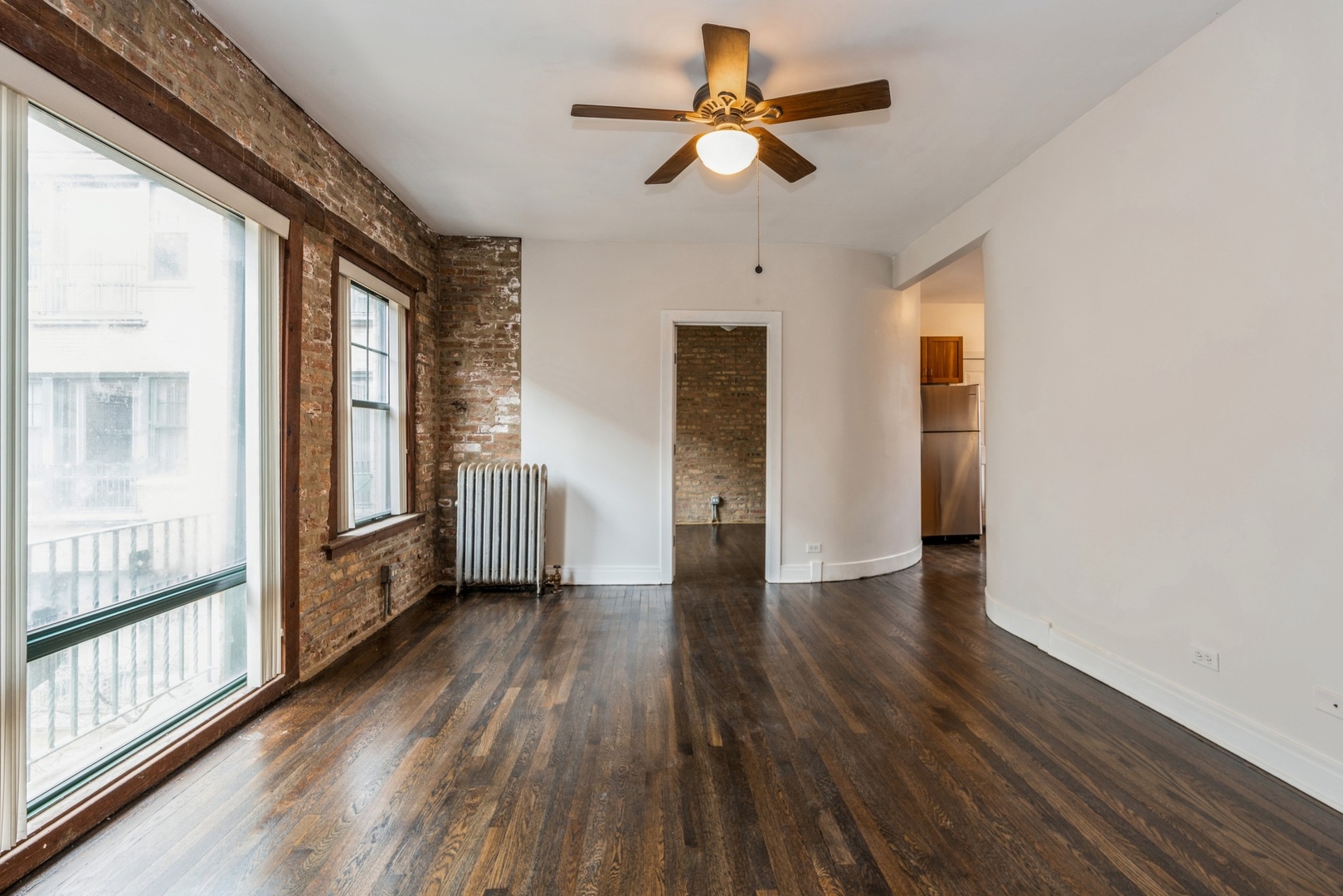 7023 North Sheridan Road, Unit 2E Chicago, IL 60626 - Photo 4 of 10 a view of a livingroom with wooden floor and a ceiling fan