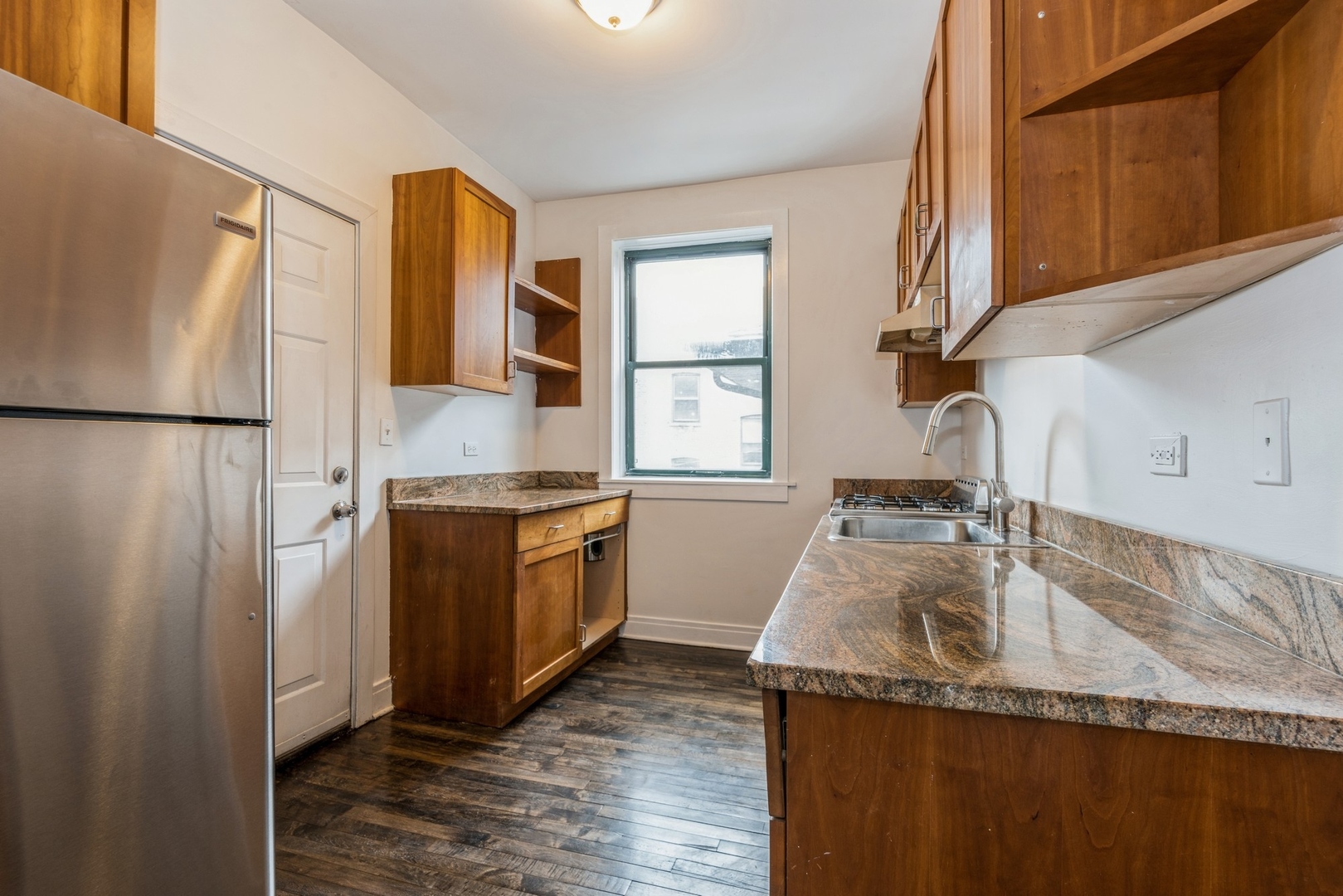 7023 North Sheridan Road, Unit 2E Chicago, IL 60626 - Photo 5 of 10 a kitchen with granite countertop a refrigerator and a sink