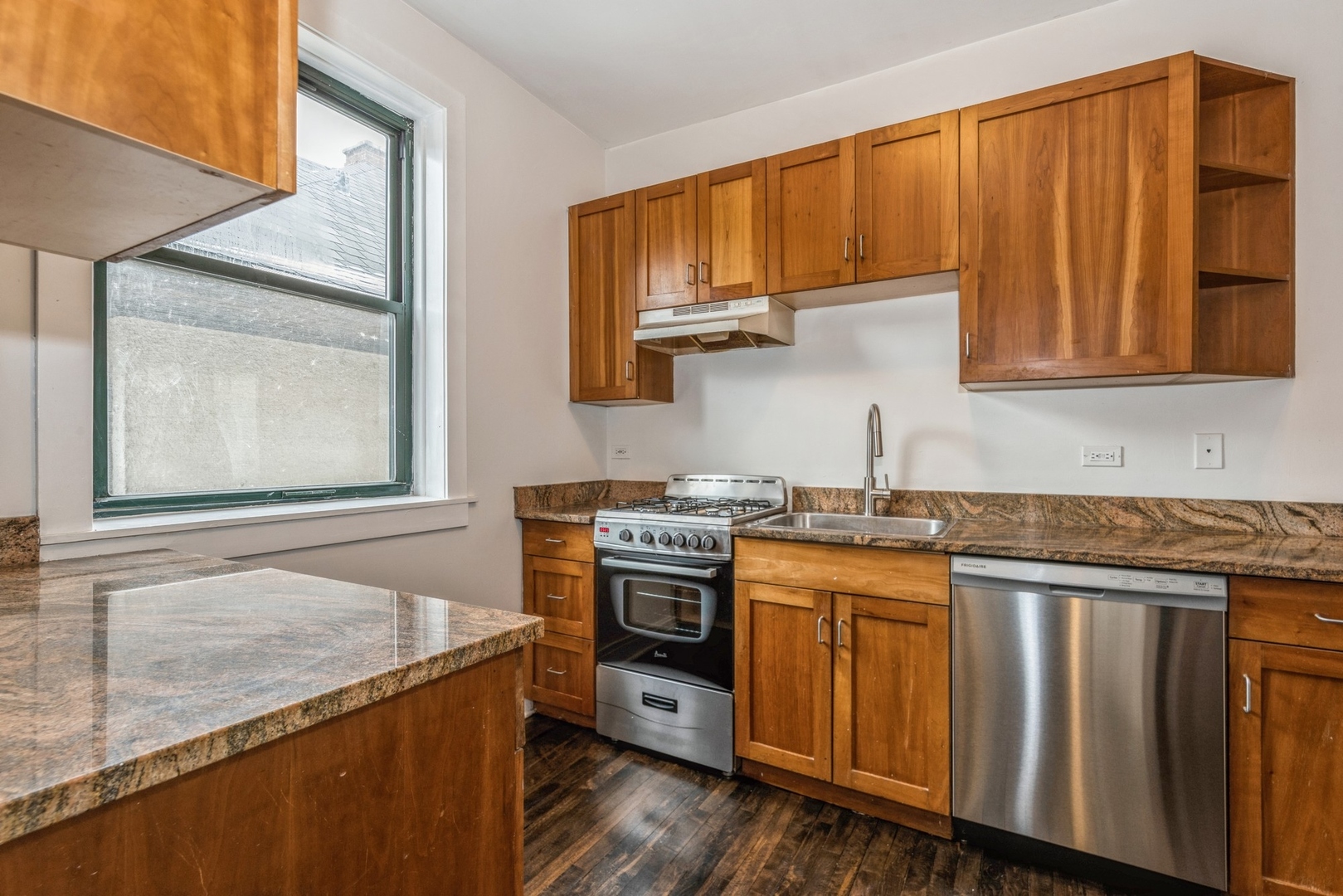 7023 North Sheridan Road, Unit 2E Chicago, IL 60626 - Photo 6 of 10 a kitchen with stainless steel appliances granite countertop a stove a sink and a microwave