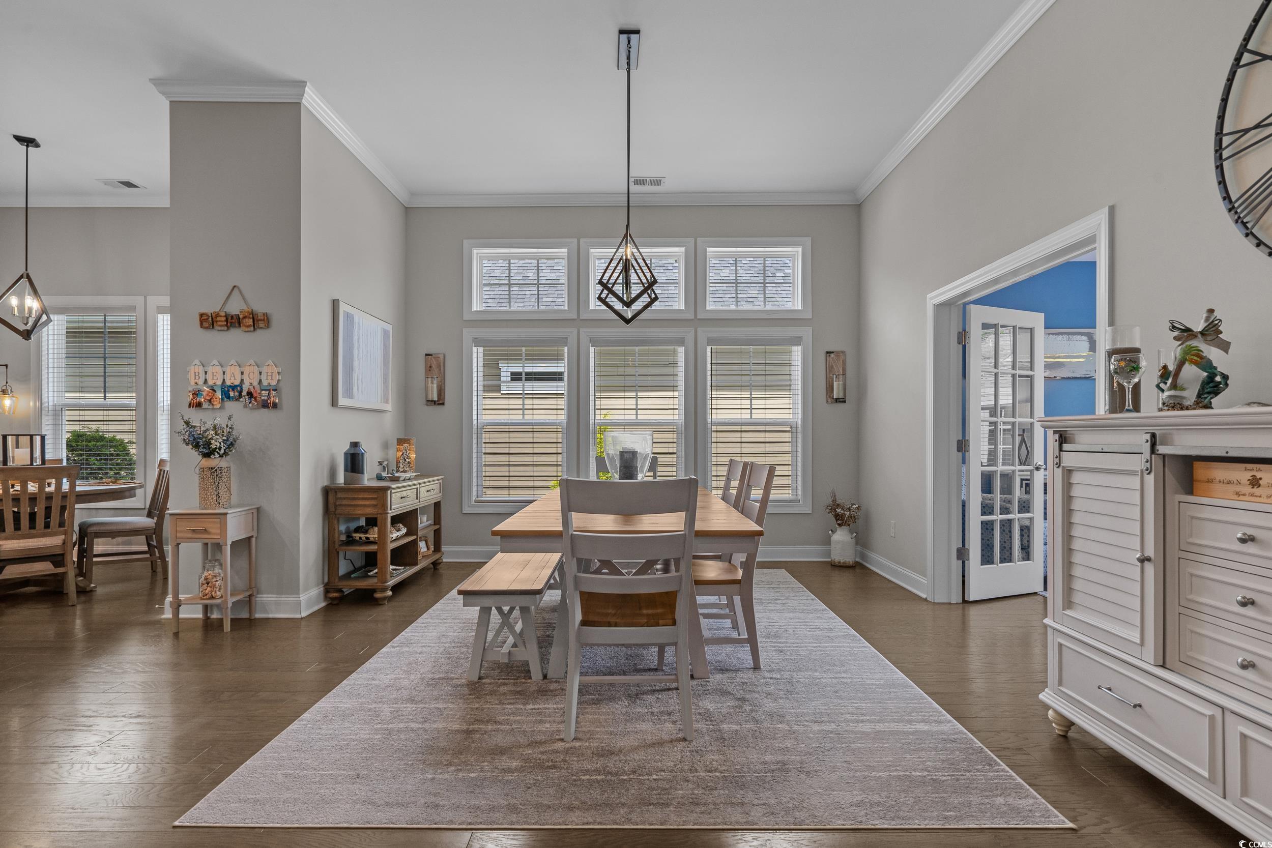1380 Culbertson Avenue Myrtle Beach, SC 29577 - Photo 12 of 50 Dining space with crown molding, baseboards, dark wood finished floors, a high ceiling, and a chandelier