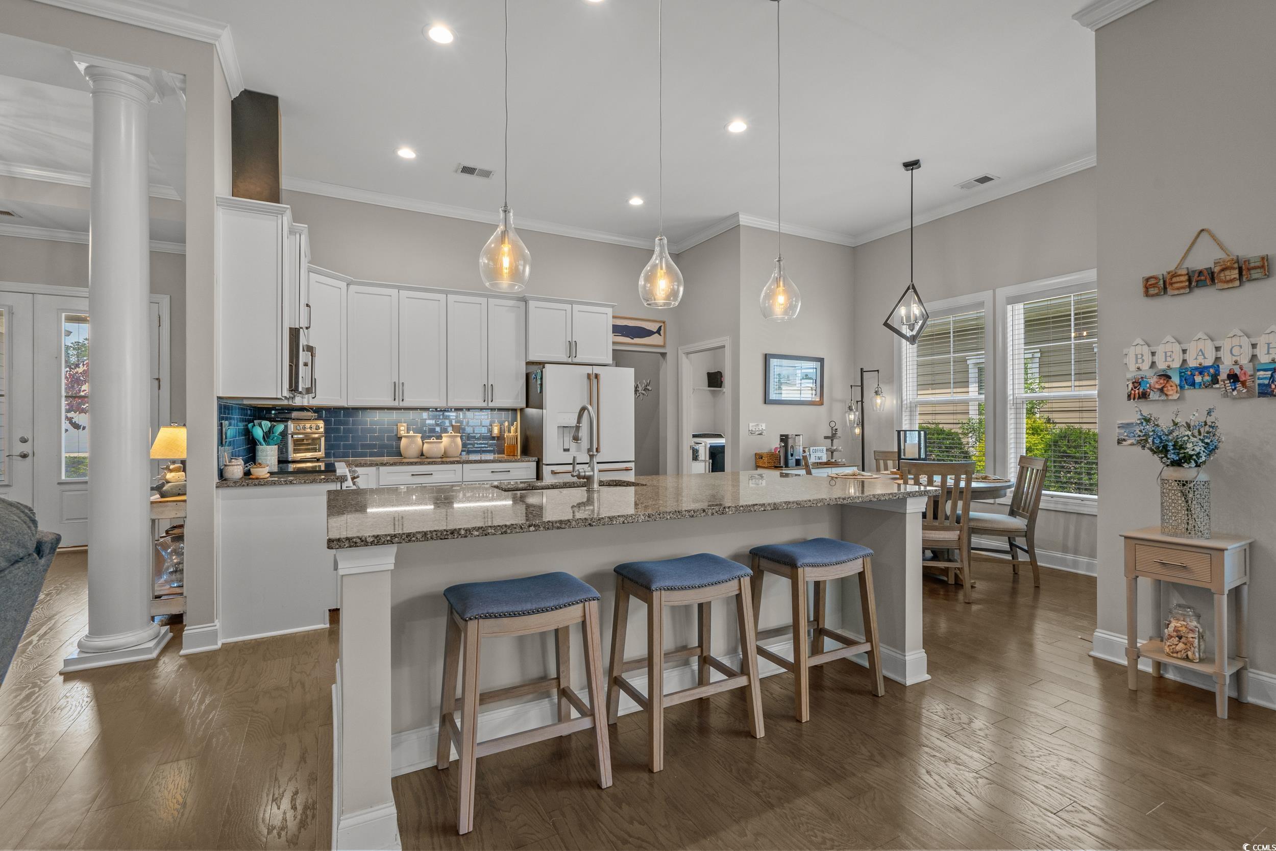 1380 Culbertson Avenue Myrtle Beach, SC 29577 - Photo 15 of 50 Kitchen featuring white fridge with ice dispenser, decorative columns, decorative backsplash, white cabinetry, and recessed lighting