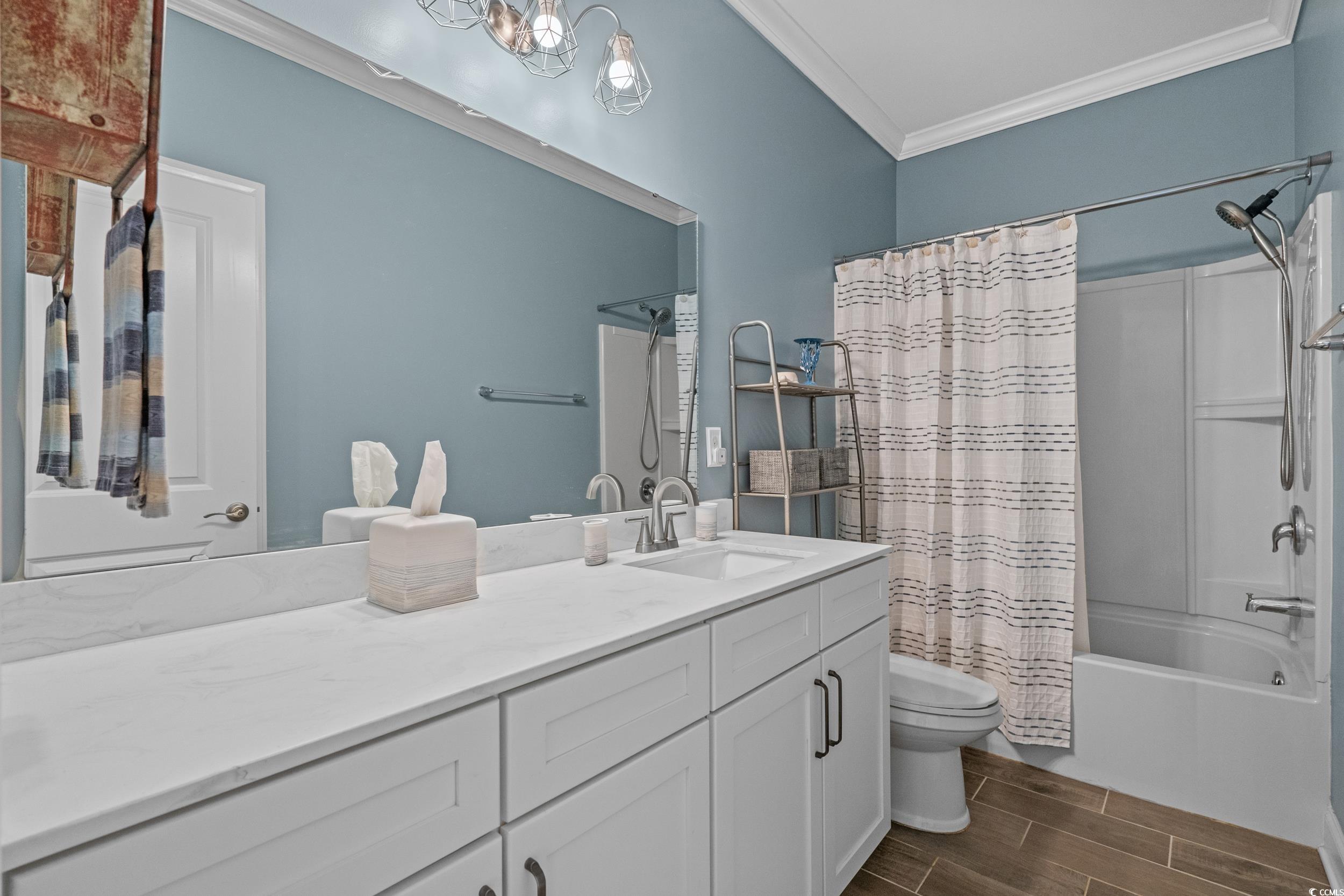 1380 Culbertson Avenue Myrtle Beach, SC 29577 - Photo 39 of 50 Bathroom featuring ornamental molding, toilet, vanity, wood finish floors, and shower / bathtub combination with curtain