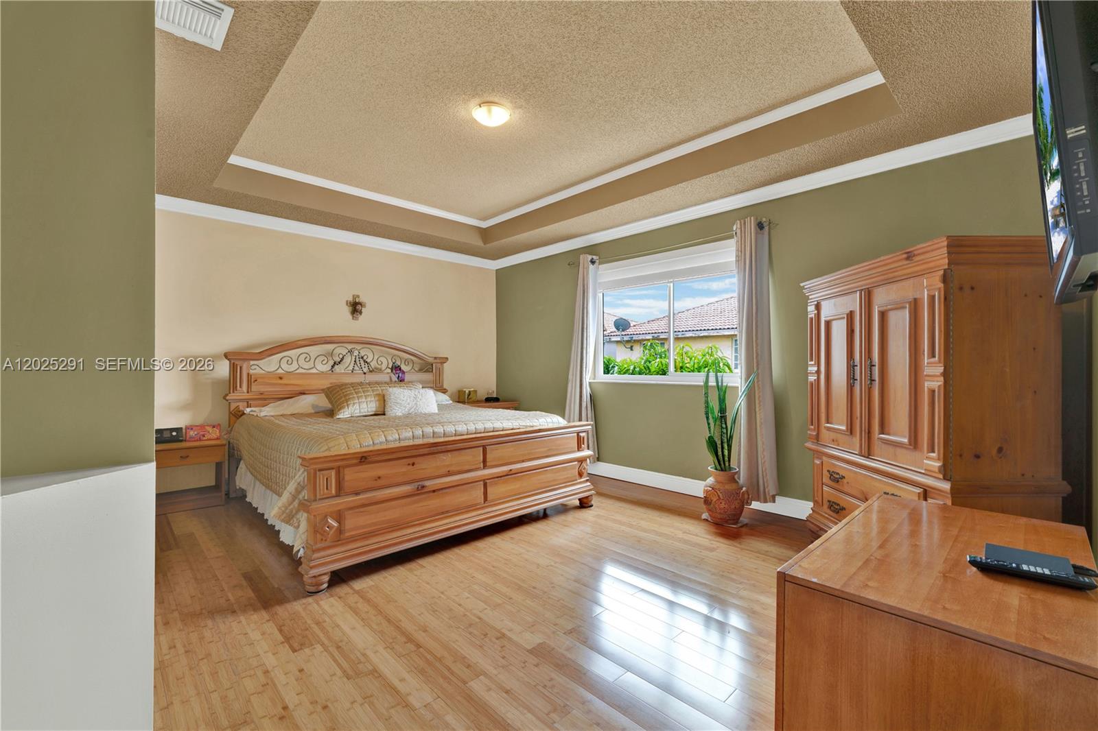 10006 Southwest 162nd Path Miami, FL 33196 - Photo 18 of 40 a bedroom with a bed table flat screen tv and a large window
