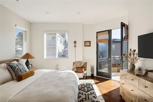a living room with furniture a flat screen tv and a floor to ceiling window
