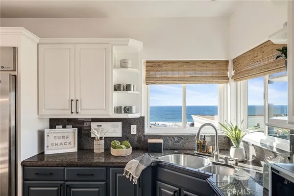 a kitchen with stainless steel appliances kitchen island granite countertop a sink and a refrigerator