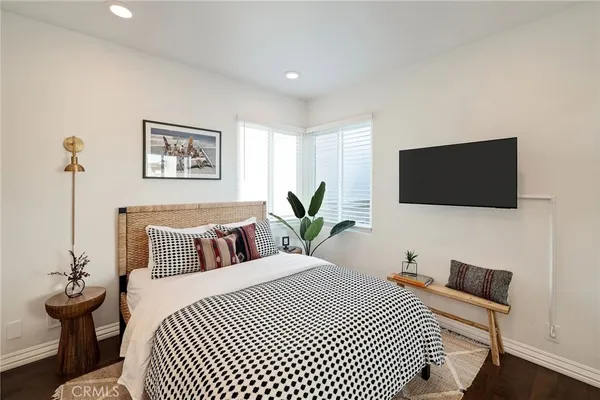 a bedroom with a bed and wooden floor