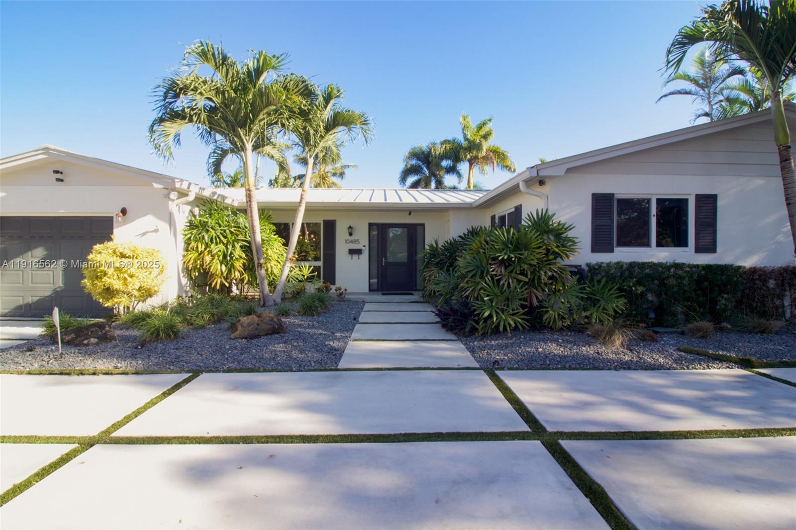 10485 Southwest 109th Street Miami, FL 33176 - Photo 2 of 45 a front view of a house with a yard and a garage