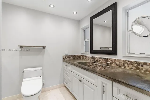 a bathroom with a toilet sink and mirror