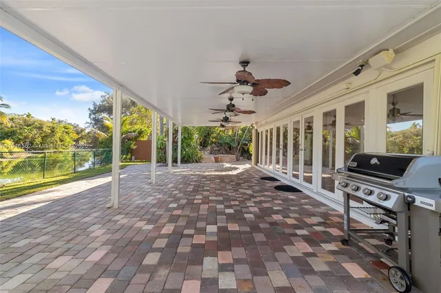 a view of a patio with couches plants and large tree
