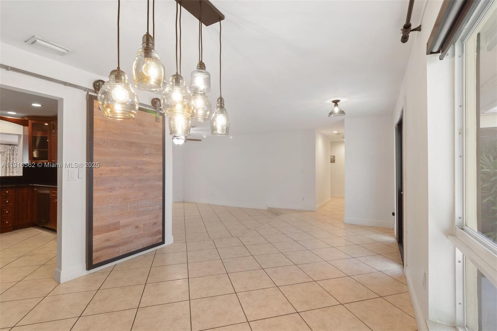10485 Southwest 109th Street Miami, FL 33176 - Photo 5 of 45 a view of an empty room and kitchen view with wooden floor