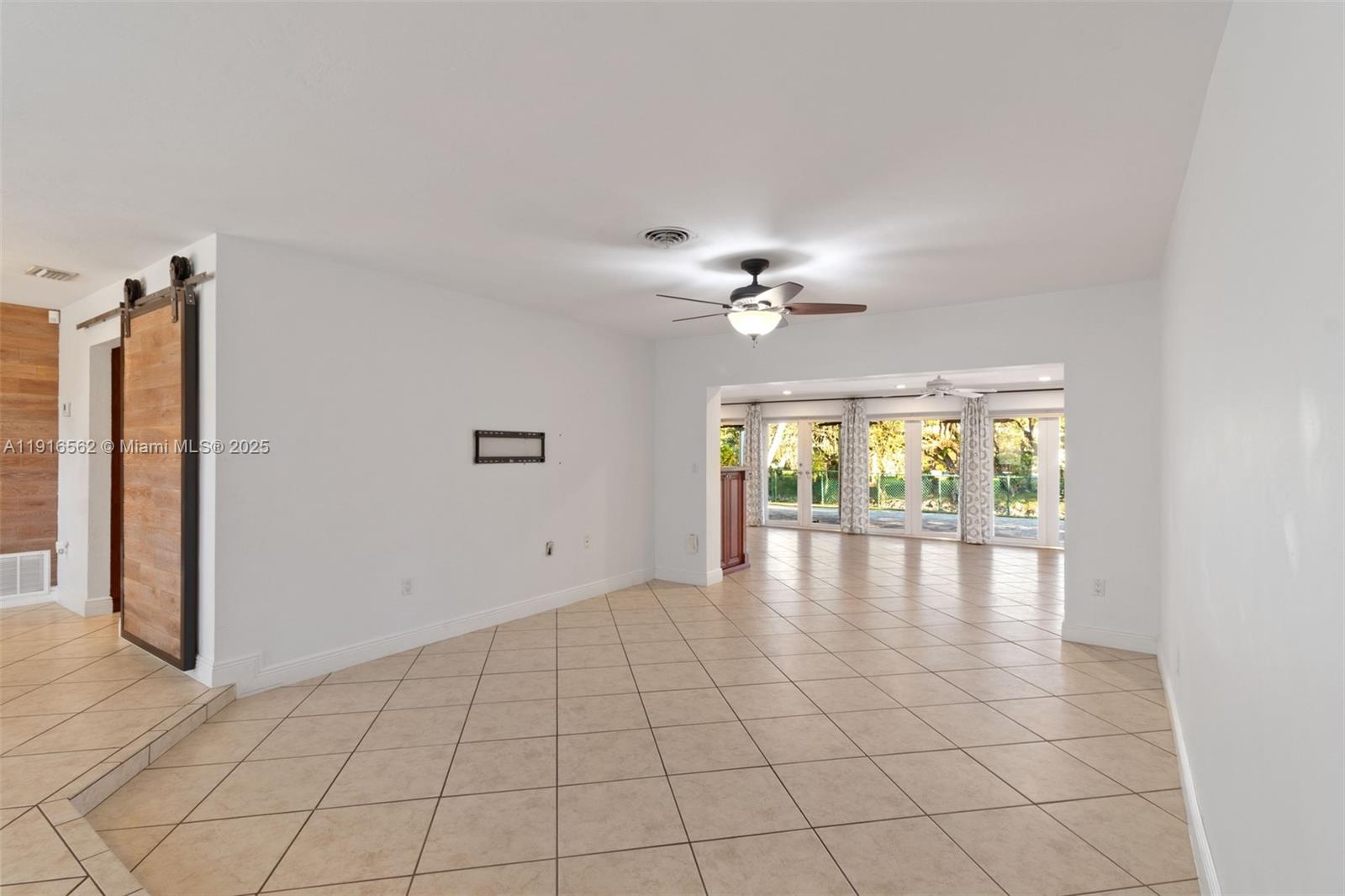 10485 Southwest 109th Street Miami, FL 33176 - Photo 9 of 45 an empty room with chandelier fan and windows