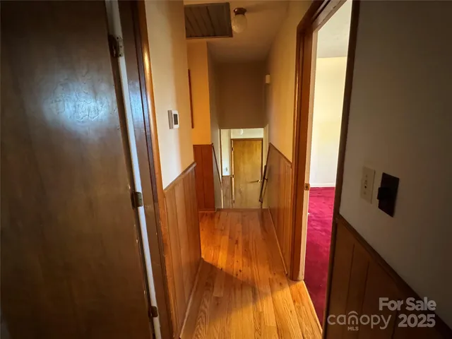 a view of backyard with large window and wooden fence