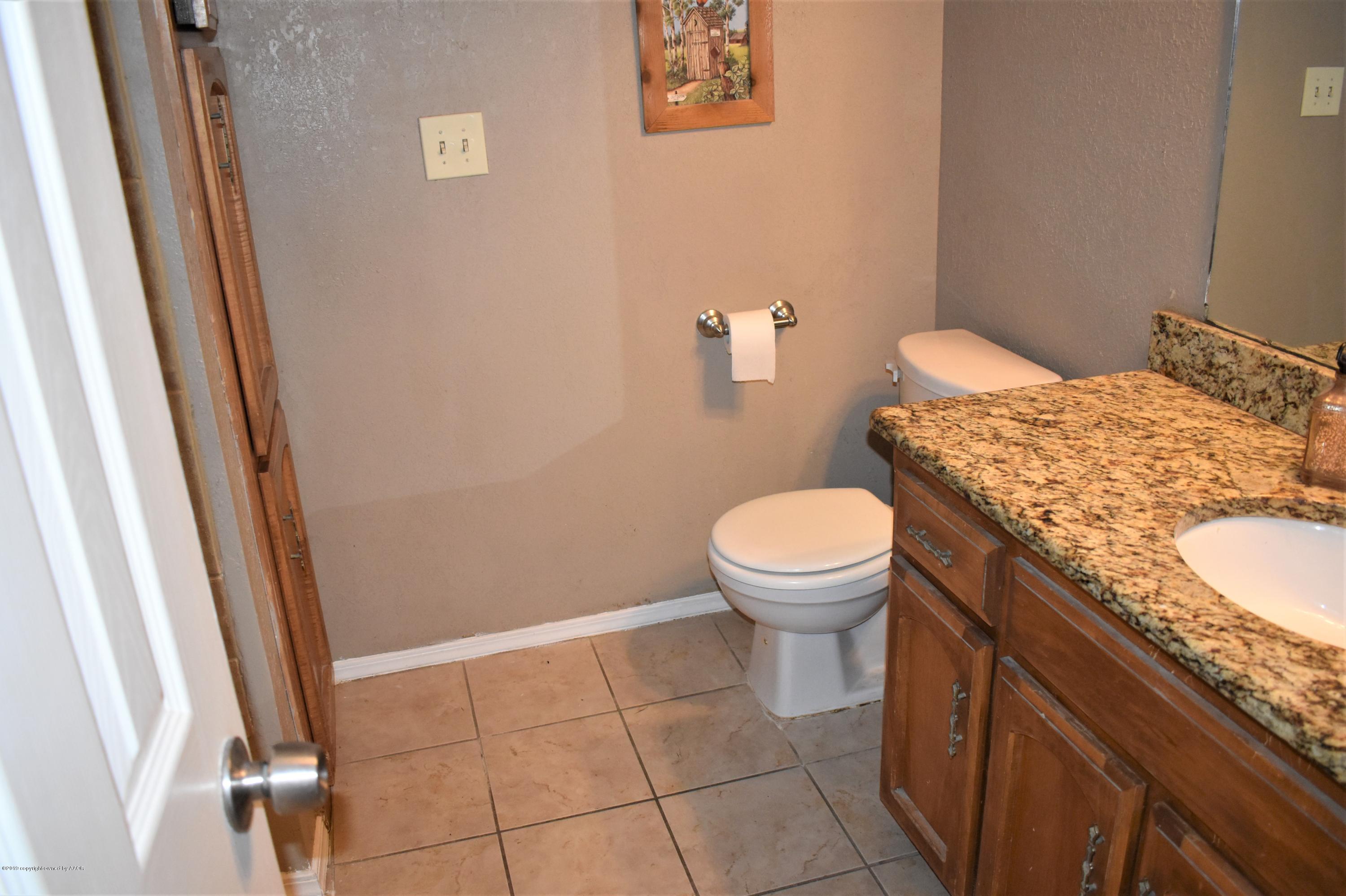 7902 Gerald Drive Amarillo, TX 79121 - Photo 11 of 17 a bathroom with a granite countertop toilet and a sink