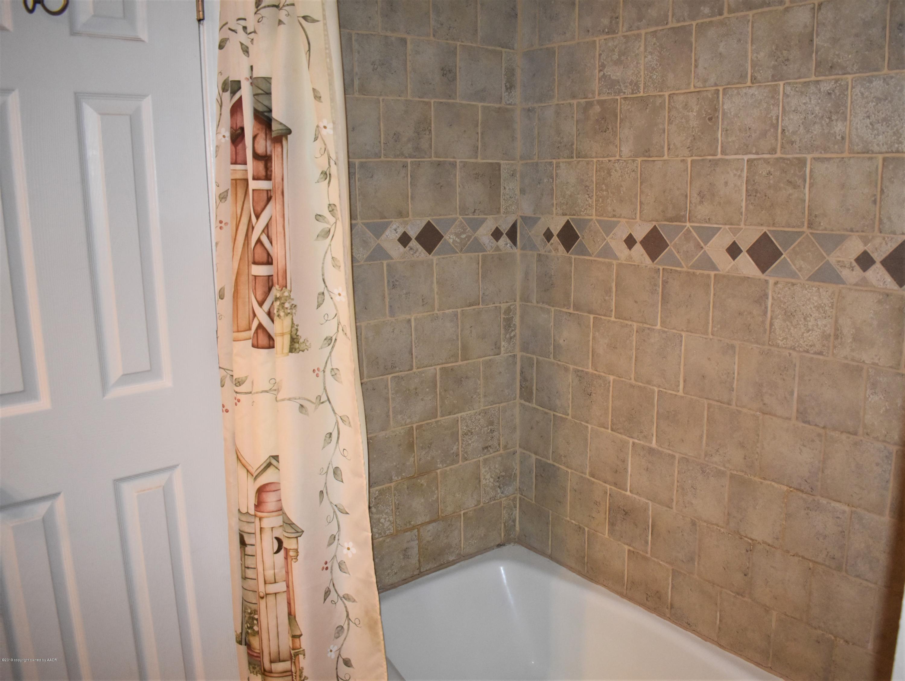 7902 Gerald Drive Amarillo, TX 79121 - Photo 12 of 17 a bathroom with a shower and a bathtub