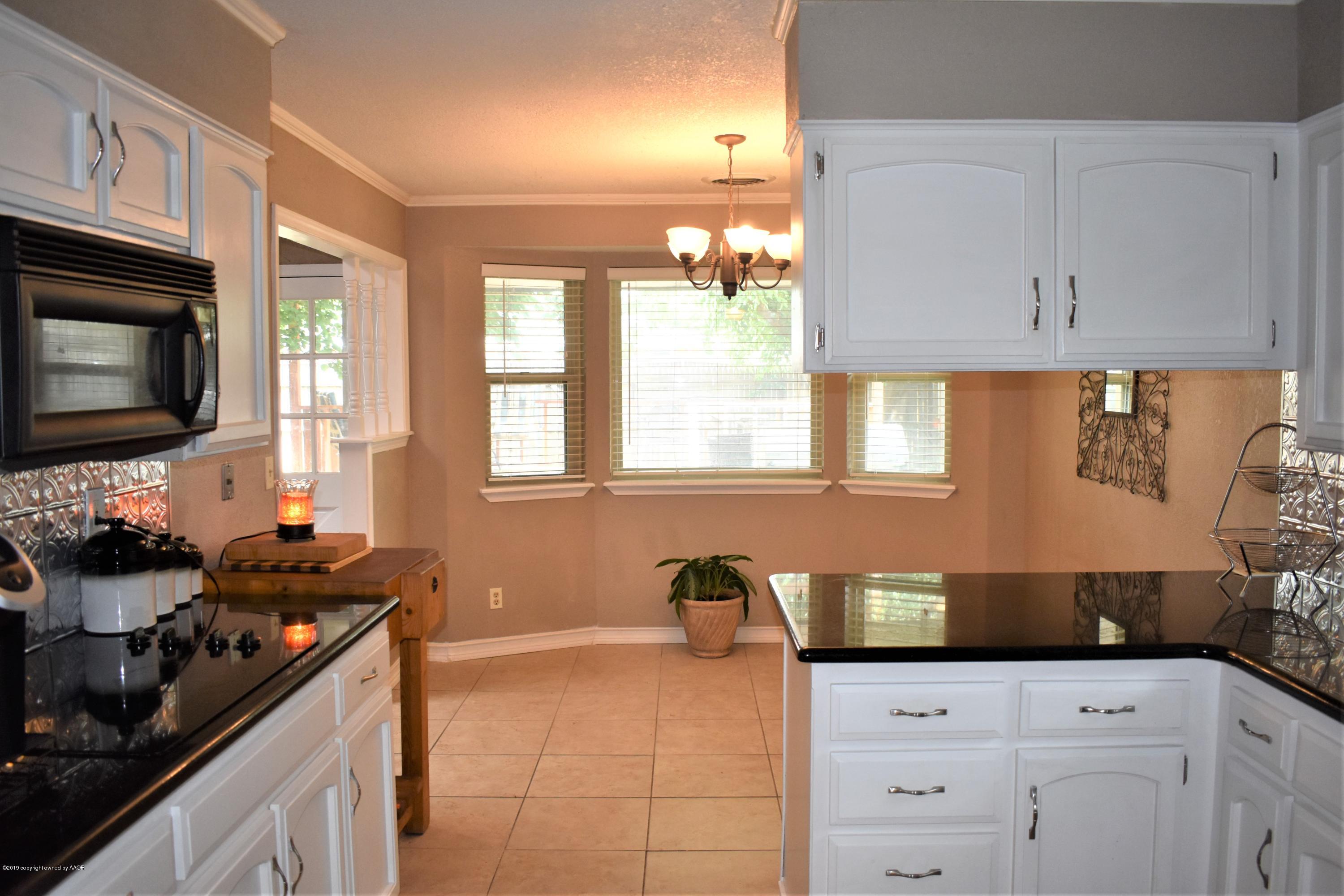 7902 Gerald Drive Amarillo, TX 79121 - Photo 14 of 17 a kitchen with granite countertop a sink a stove and cabinets