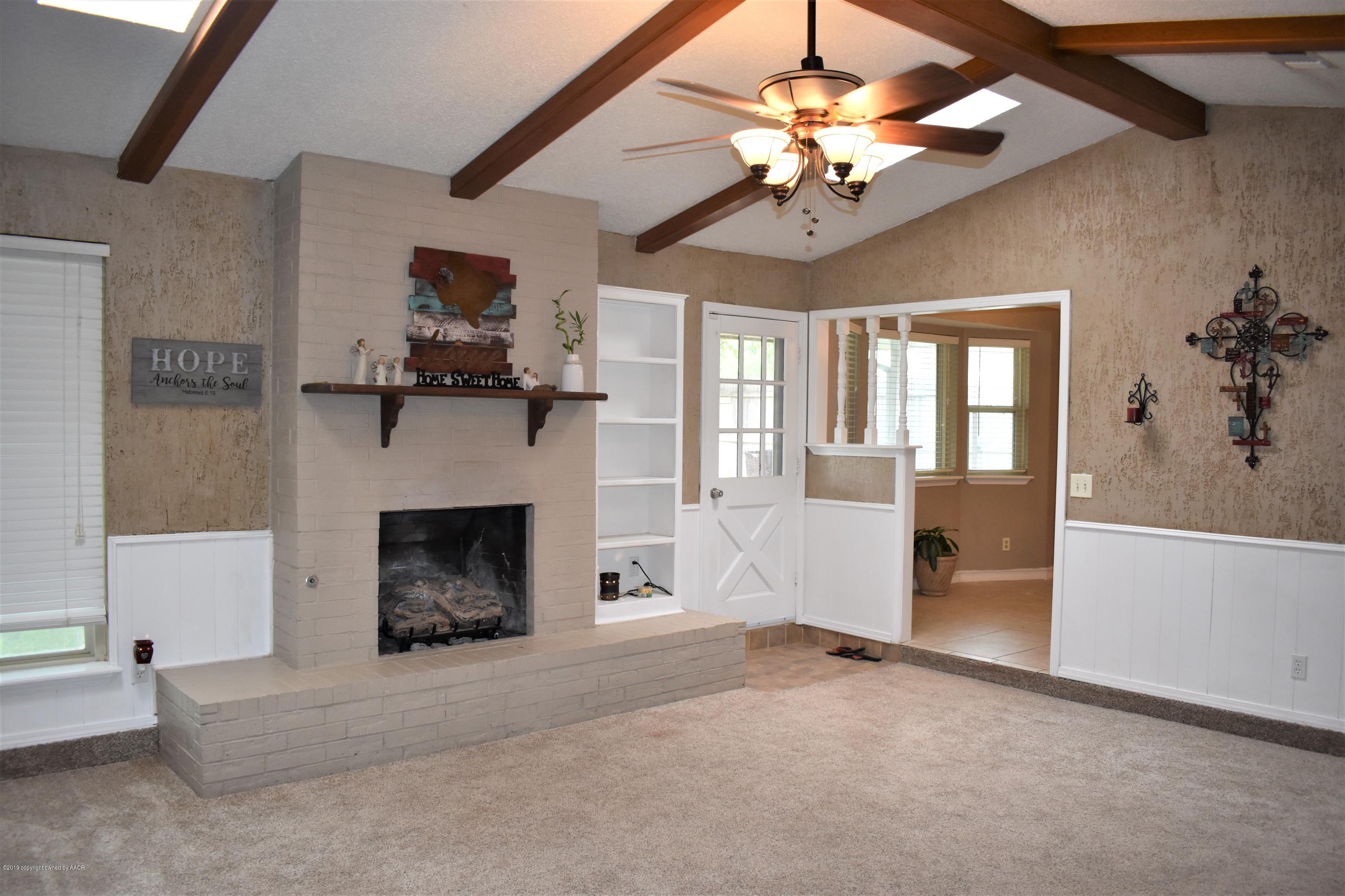 7902 Gerald Drive Amarillo, TX 79121 - Photo 2 of 17 a view of a livingroom with a fireplace a chandelier and stairs