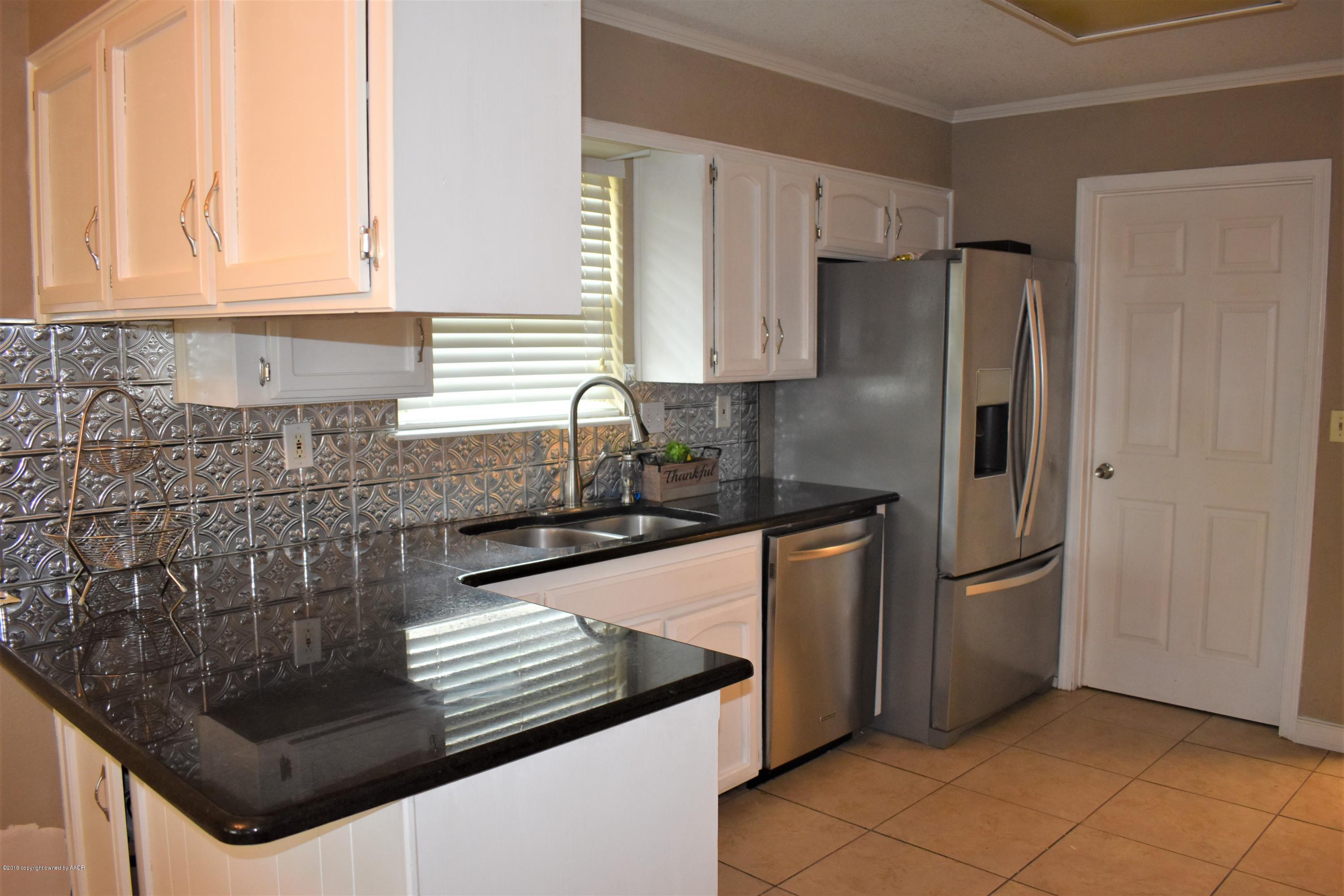 7902 Gerald Drive Amarillo, TX 79121 - Photo 3 of 17 a kitchen with granite countertop a refrigerator and a sink