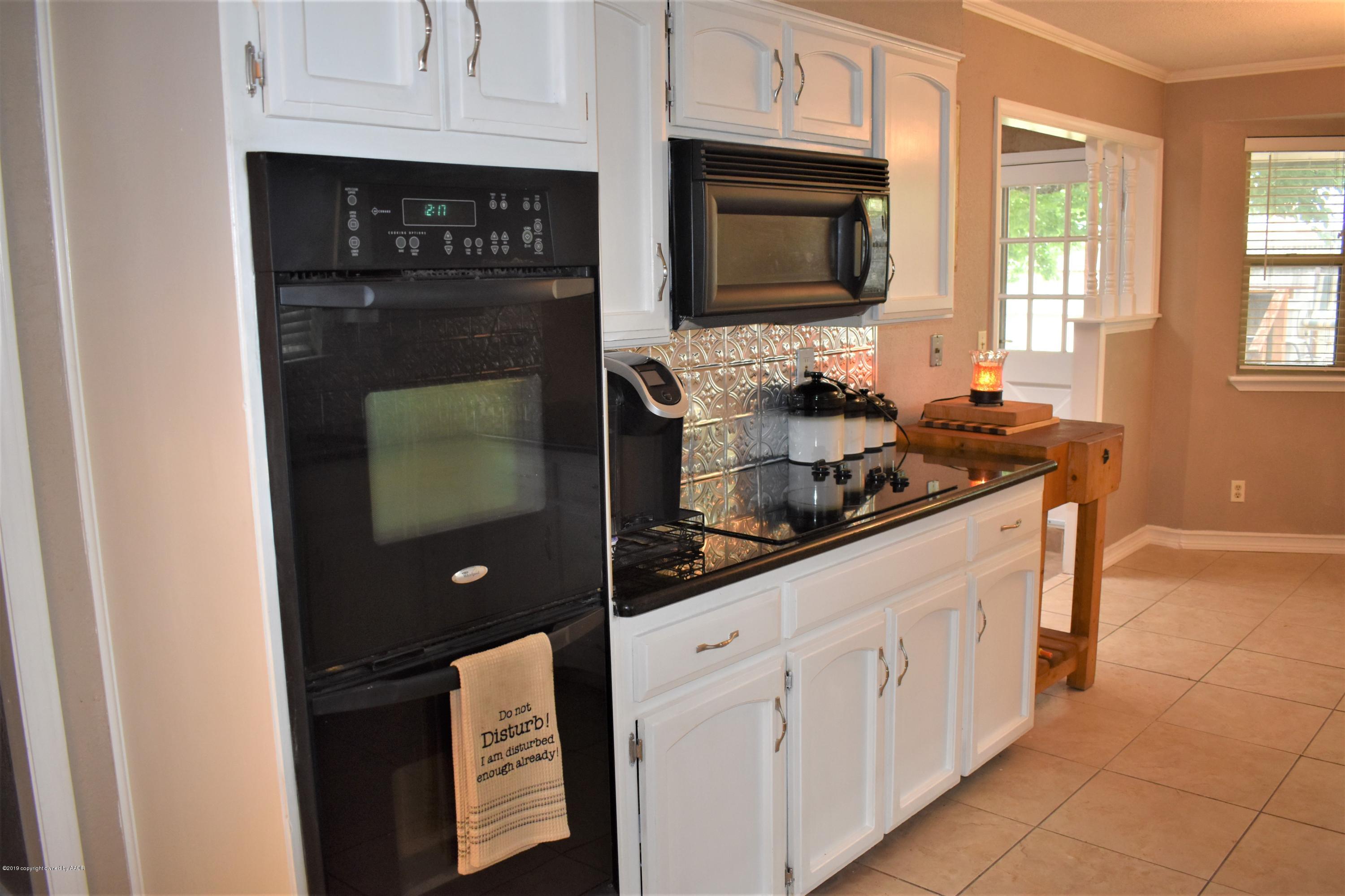 7902 Gerald Drive Amarillo, TX 79121 - Photo 4 of 17 a kitchen with stainless steel appliances white cabinets and a stove top oven