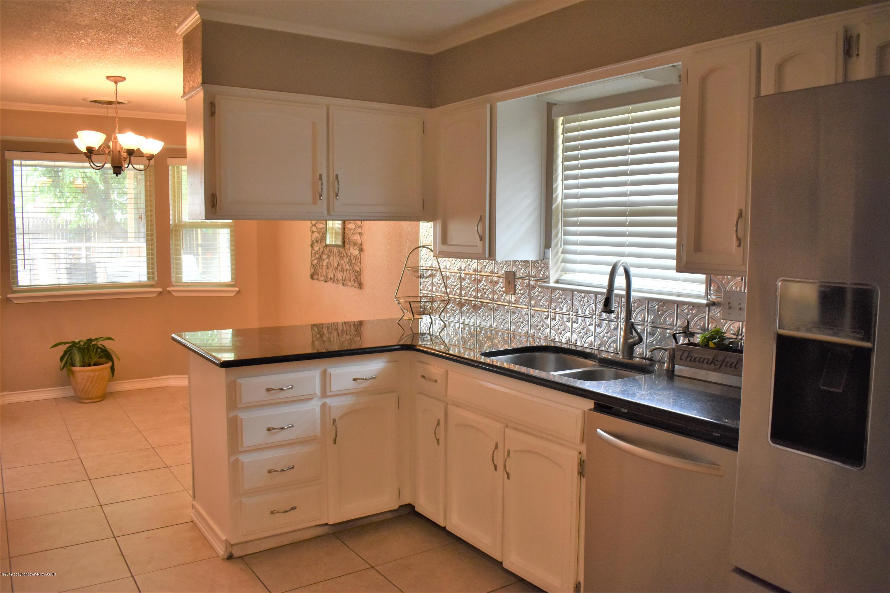 7902 Gerald Drive Amarillo, TX 79121 - Photo 5 of 17 a kitchen with granite countertop a sink and a stove