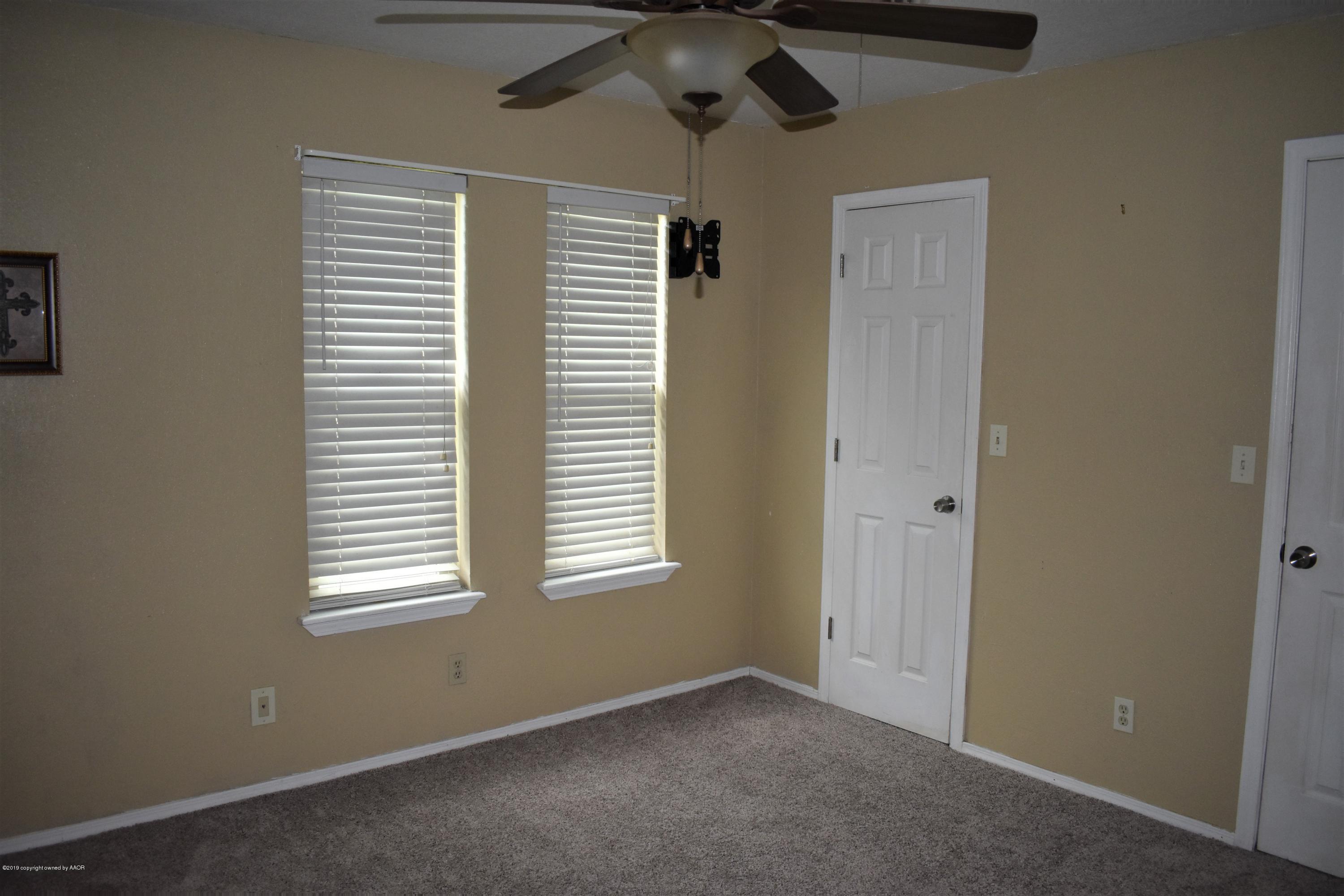 7902 Gerald Drive Amarillo, TX 79121 - Photo 7 of 17 an empty room with a window and a ceiling fan