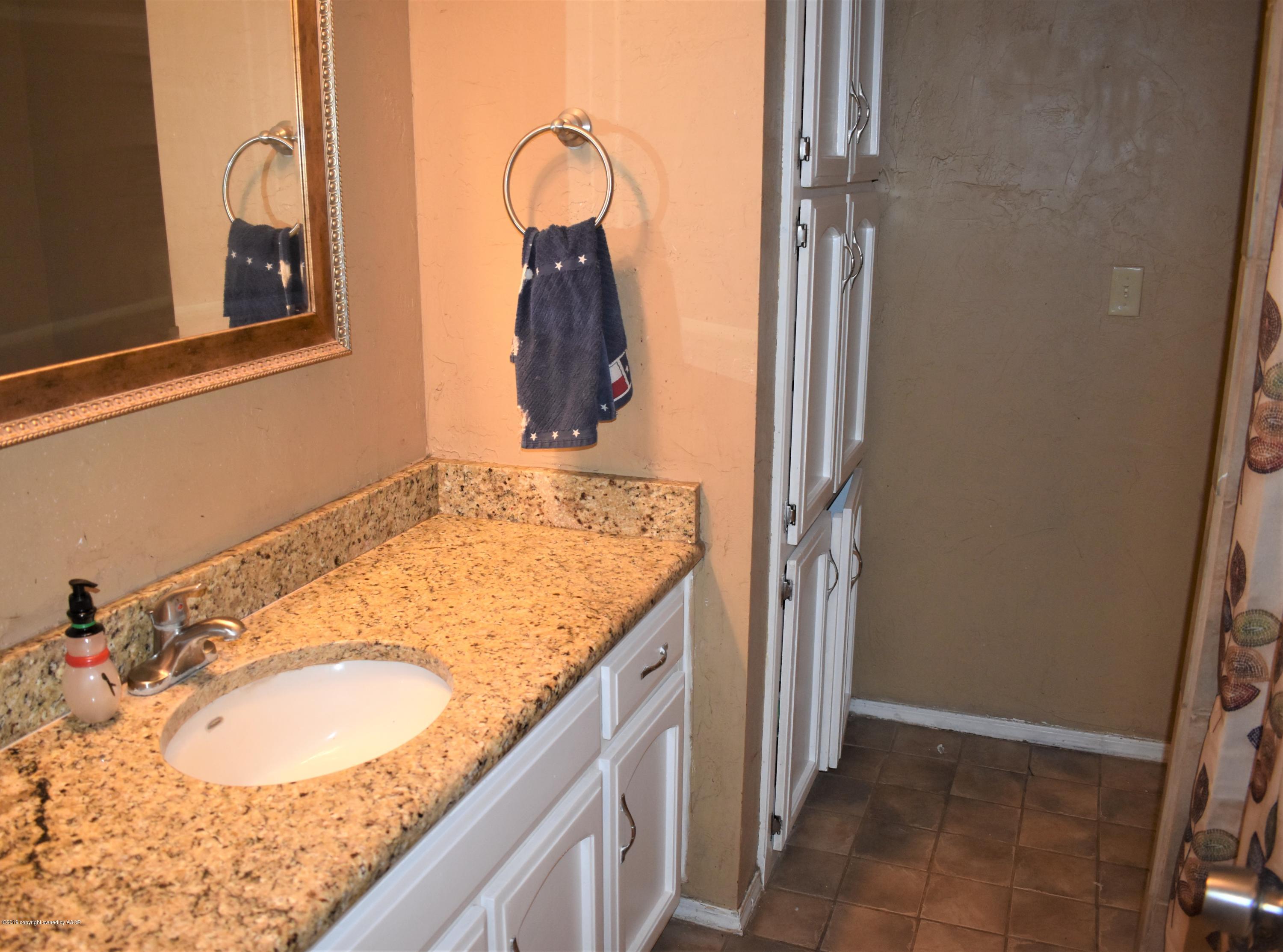 7902 Gerald Drive Amarillo, TX 79121 - Photo 10 of 17 a bathroom with a granite countertop sink and a mirror