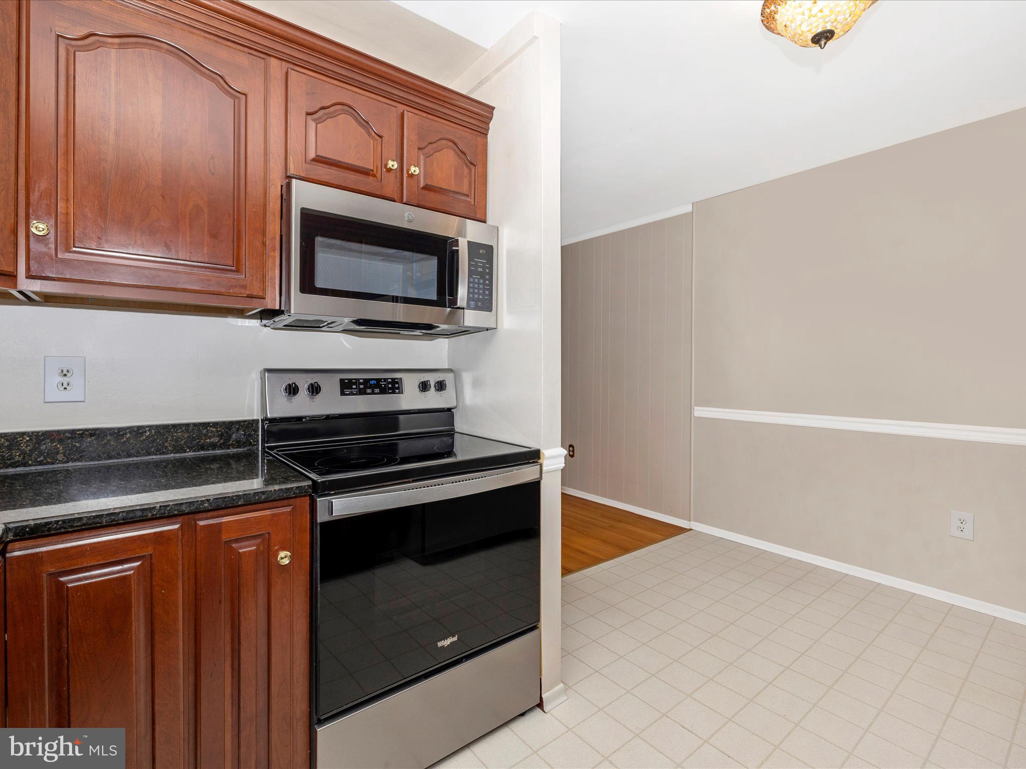 25204 Frederick Road Clarksburg, MD 20871 - Photo 18 of 58 a kitchen with granite countertop a stove and a microwave with cabinets