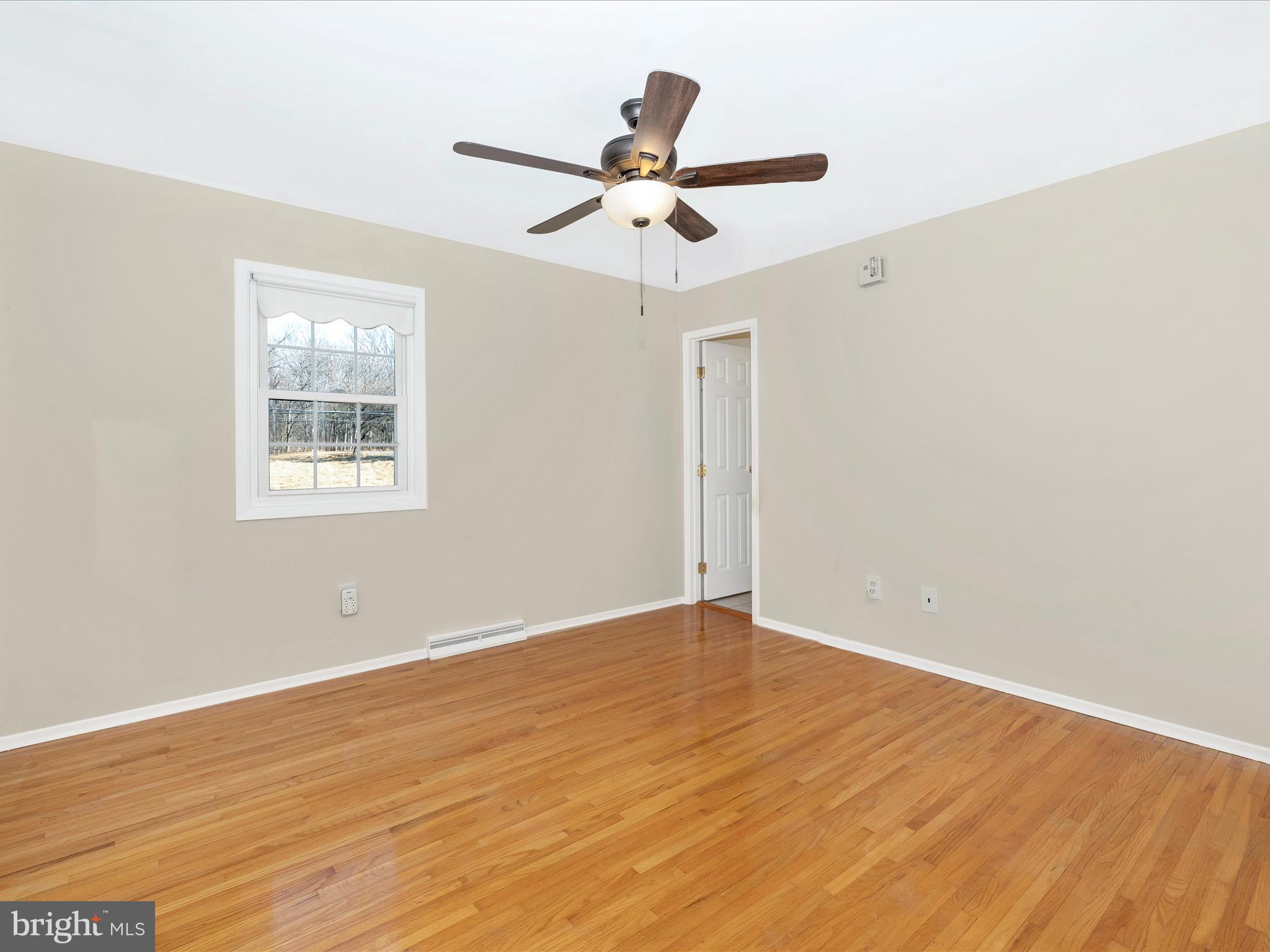 25204 Frederick Road Clarksburg, MD 20871 - Photo 25 of 58 a view of an empty room with wooden floor and a ceiling fan