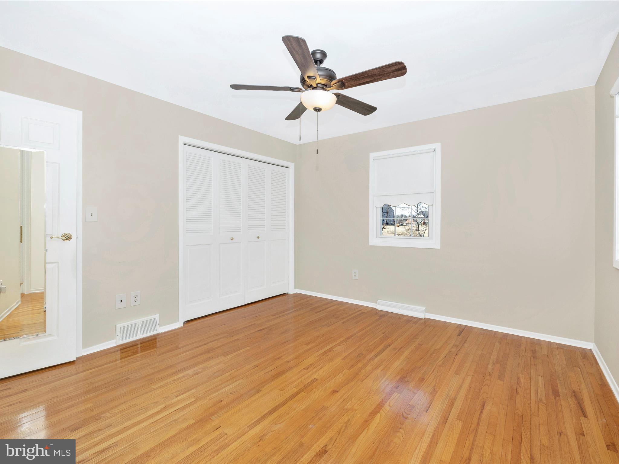 25204 Frederick Road Clarksburg, MD 20871 - Photo 27 of 58 an empty room with wooden floor ceiling fan and windows