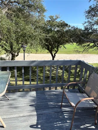 a view of a patio with table and chairs with wooden floor and fence