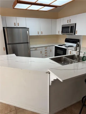 a kitchen with a sink a refrigerator and cabinets