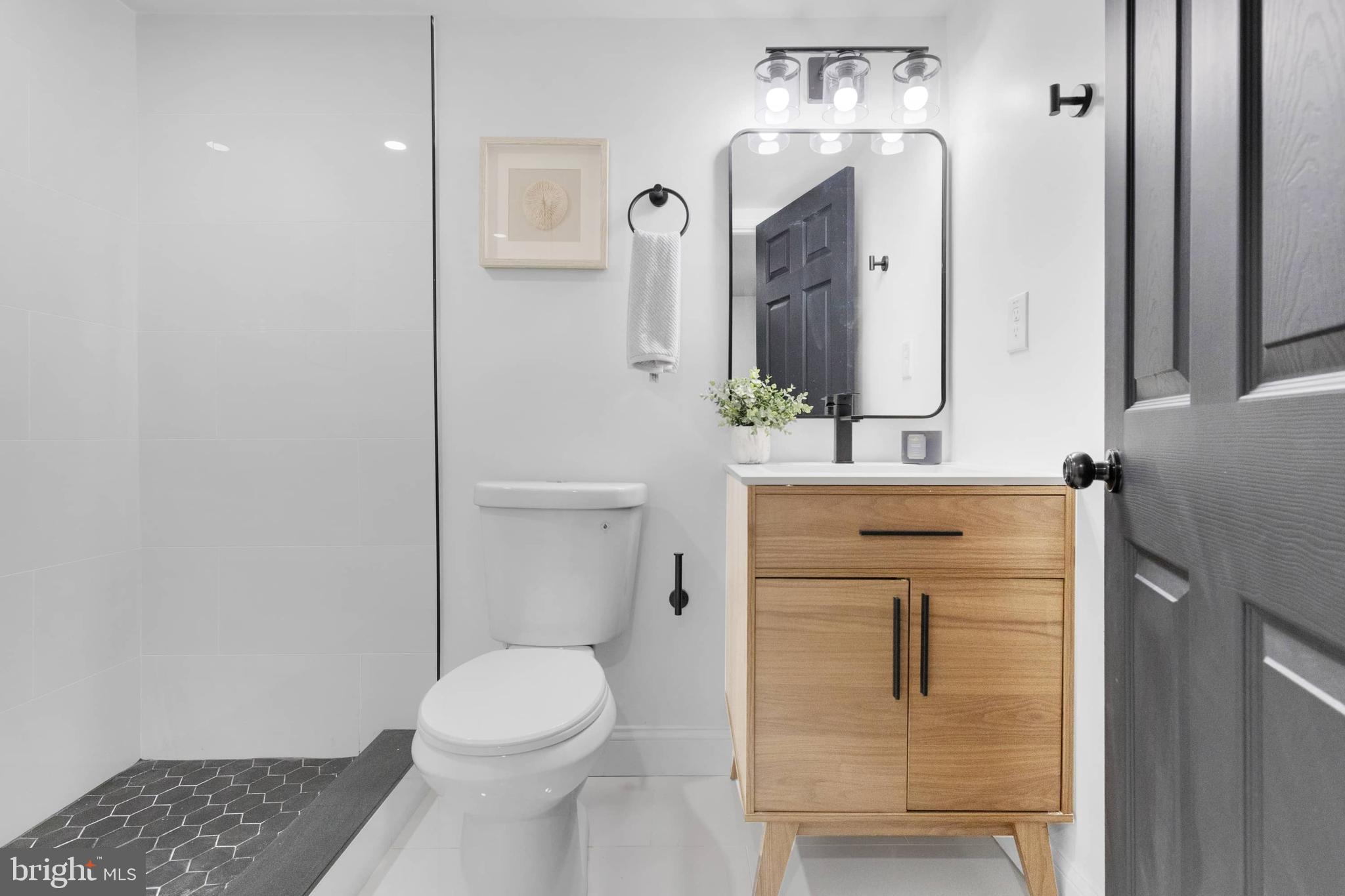 1403 Stonewood Road Baltimore, MD 21239 - Photo 24 of 36 a bathroom with a toilet sink and mirror