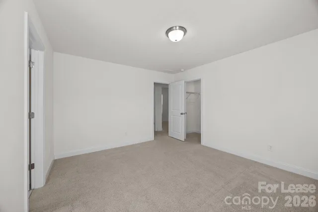 a spacious bathroom with a granite countertop sink a toilet a mirror and shower