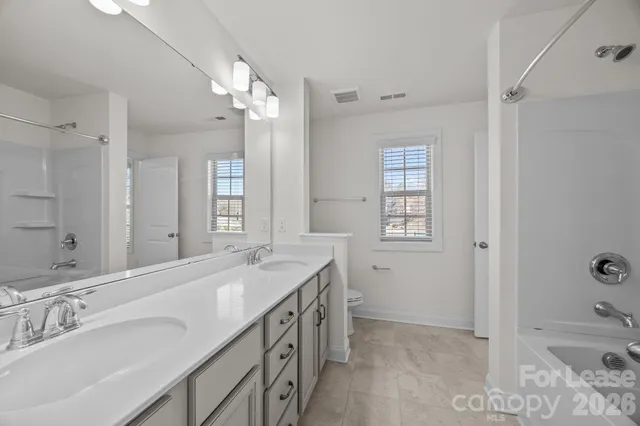 an empty room with fan and windows